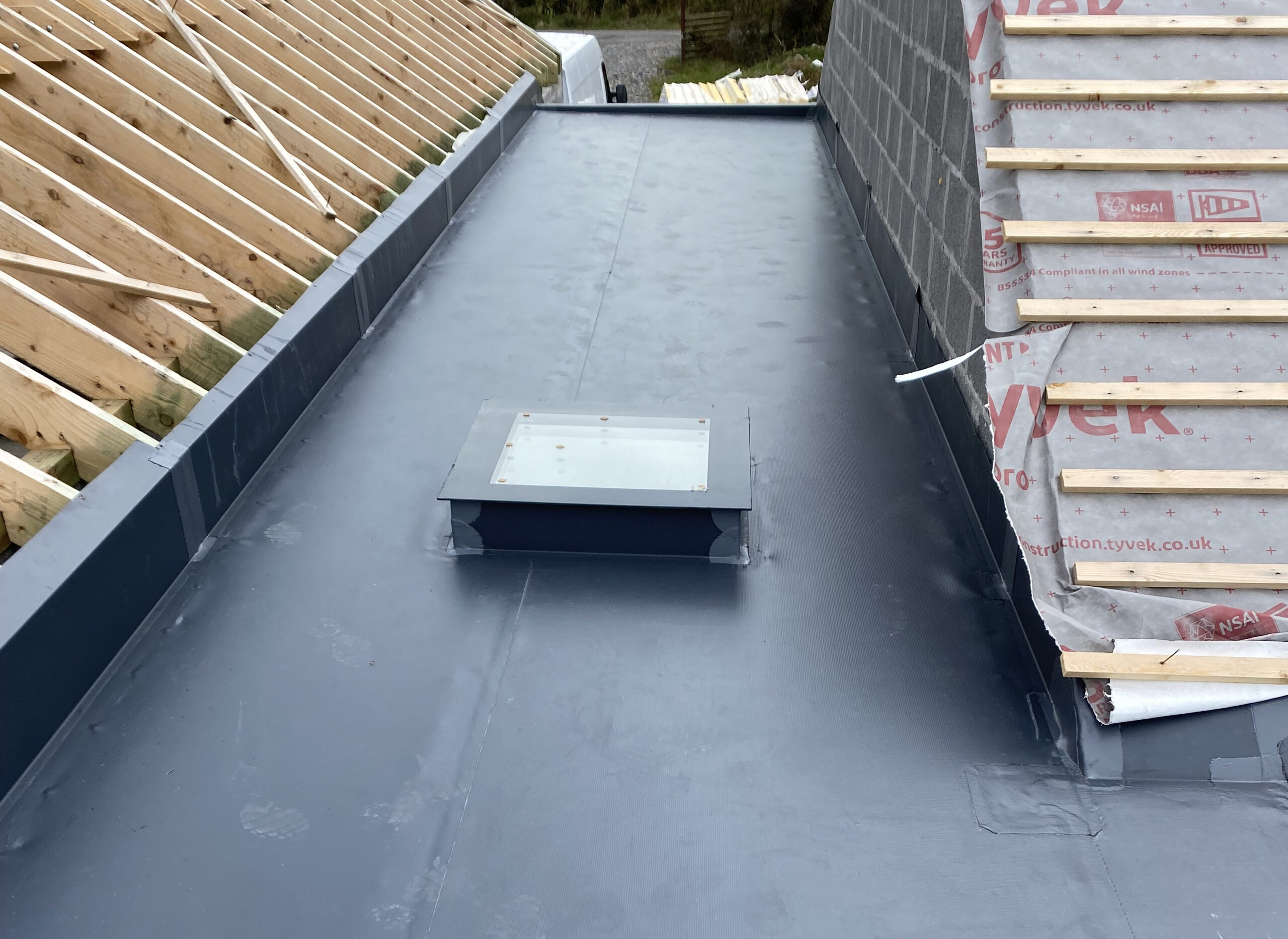 Square rooflight on flat roof between 2 other sloped roofs - roofing contractor